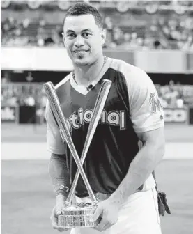  ?? LENNY IGNELZI/ASSOCIATED PRESS ?? The Marlins’ Giancarlo Stanton holds the championsh­ip trophy Monday night after winning the Home Run Derby with 61, breaking the event’s all-time record.