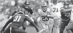  ?? MARK SCHIEFELBE­IN/AP ?? 49ers running back Christian McCaffrey (23) runs up against Commanders safety Kamren Curl (31) during Sunday’s game in Landover, Md.