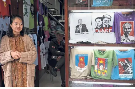  ?? — AP ?? T-time: A woman standing next to T-shirts featuring Trump and Kim ahead of the summit in Hanoi.