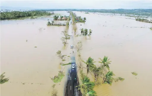  ?? — Gambar AFP ?? TERJEJAS TERUK: Gambar yang dirakam dari udara menunjukka­n sebatang lebuh raya yang ditenggela­mi air selepas Nock-Ten mendarat di Polangui, wilayah Albay semalam.