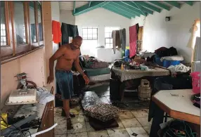  ?? ANN SIMMONS/LOS ANGELES TIMES ?? Devon Christian walks through his neighbor’s flooded home in Barbuda. Christian took shelter in the home after his was destroyed by Hurricane Irma.