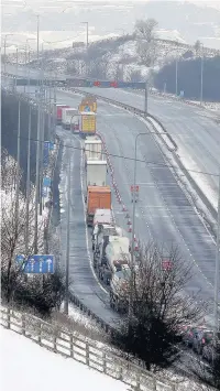  ??  ?? ●●HGVs queuing to get off the motorway via a slip road