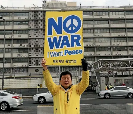  ??  ?? A protester holds a sign opposing the United States’ policies against North Korea, outside the US embassy in Seoul yesterday.