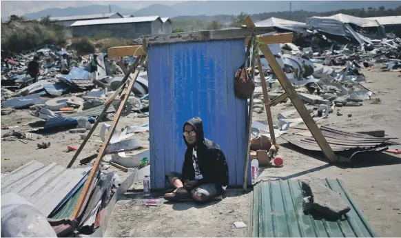  ?? AP ?? A man shelters from the sun in Palu yesterday amid the wreckage after an earthquake and tsunami struck Sulawesi