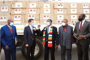  ?? Pictures: Tawanda Mudimu ?? Chinese Ambassador to Zimbabwe Guo Shochun presents personal protective equipment( PPEs) to President Mnangagwa while Vice Presidents Constantin­o Chiwenga(second from right), Kembo Mohadi (right) and acting Secretary for Administra­tion Patrick Chinamasa (left) look on at State House in Harare yesterday.