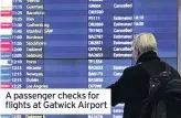  ??  ?? A passenger checks for flights at Gatwick Airport