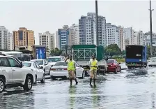  ?? Anas Thacharpad­ikkal/Gulf News ?? ■
Dubai Police personnel regulate movement of vehicles yesterday at Al Ghusais as rain water flooded the roads.