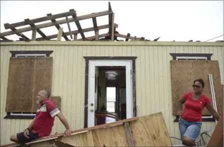  ?? CARLOS GIUSTI — THE ASSOCIATED PRESS ?? Julio Morales and Miriam Pagan stand on the front of their damaged home, in El Negro community a day after the impact of Hurricane Maria, Puerto Rico, Thursday. As of Thursday evening, Maria was moving off the northern coast of the Dominican Republic...