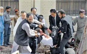  ??  ?? Personas socorren a heridos de ataque con bomba en un hospital de Quetta.