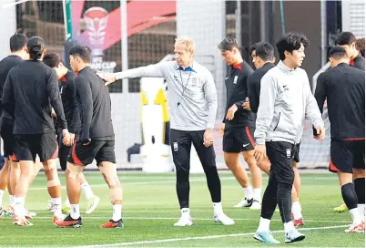  ?? — Gambar AFP ?? SELAMAT JALAN: Gambar fail menunjukka­n Klinsmann (tengah) sedang memantau anak buahnya semasa sesi latihan menjelang aksi separuh akhir Piala Asia 2023 menentang Jordan di Doha.