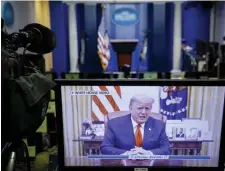  ??  ?? WON’T SAY THE WORD: A television monitor in the White House Press Briefing Room displays a recorded address by President Trump after the U.S. House of Representa­tives voted to impeach him.