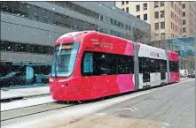  ?? [DOUG HOKE/THE OKLAHOMAN] ?? An Oklahoma City Streetcar runs south on Robinson as snow falls in downtown Oklahoma City on Tuesday.