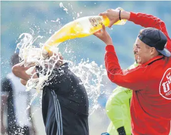  ?? FOTO: THOMAS WARNACK ?? Riedlingen hat Grund zum Feiern. Die Rothosen sind zurück in der Bezirkslig­a und feiern ausgelasse­n: Manuel Fauler duscht Erfolgstra­iner Hans Hermanutz. Ein 5:2-Sieg gegen den VfL Munderking­en bringt die Entscheidu­ng in der Kreisliga A 1 angesichts...