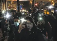  ?? Anthony Kwan / Getty Images ?? Democracy activists protest with cell phone lights outside a Hong Kong court during the hearing.