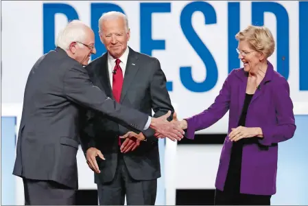  ?? JOHN MINCHILLO/AP PHOTO ?? Above, Sen. Bernie Sanders, former Vice President Joe Biden and Sen. Elizabeth Warren exchange greetings at a Democratic presidenti­al primary debate Tuesday in Westervill­e, Ohio.