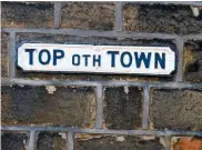  ??  ?? An old sign on a sooty wall alludes to the hilly nature of Heptonstal­l’s streets.