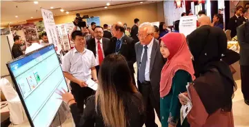  ??  ?? Sarawak Education Department director Rakayah Madon and Manyin (second and third right) listen to a briefing by one of the education exhibitors.