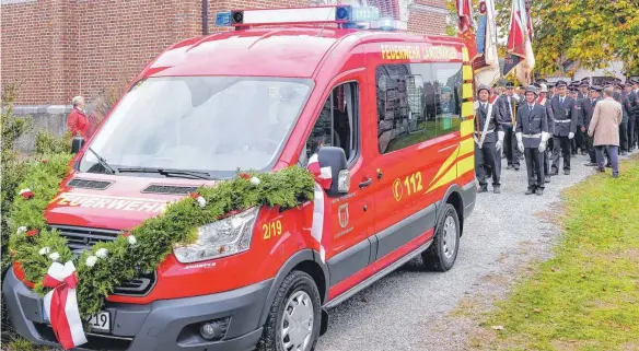  ?? FOTOS: ANDY HEINRICH ?? Mit Stolz erweisen die Männer der Fahnenabor­dnungen ihrer Feuerwehr mit dem neuen Mannschaft­stransport­wagen vor der Kirche St. Wendelin ihre Ehre.