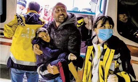  ?? UGUR YILDIRIM DIA VIA AP ?? A boy is carried to an ambulance after being injured in Monday’s 6.4 magnitude earthquake in Hatay province in Turkey.