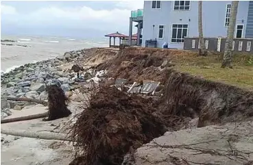  ?? ?? Sebahagian pagar rumah penduduk runtuh, manakala jalan pantai di Kampung Tanjong, Batu Rakit rosak teruk akibat hakisan.