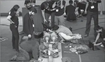  ?? MATHEW MCCARTHY, RECORD STAFF ?? UW students scramble to repair the Waterloop on a track at Federation Hall on Friday. The students hoped to demonstrat­e the prototype they designed and built for an upcoming competitio­n, but couldn’t get it to run.