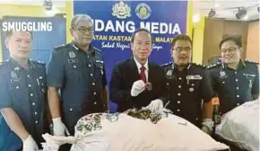  ?? PIC
BY AMNIERA NAZIERA AMRAN ?? Sabah Customs director Datuk Dr Janathan Kandok (centre) showing the seized pangolin scales in Kota Kinabalu yesterday.