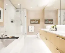  ??  ?? Bathrooms are outfitted with porcelain tile flooring and master suites showcase frameless glass showers and plenty of storage.