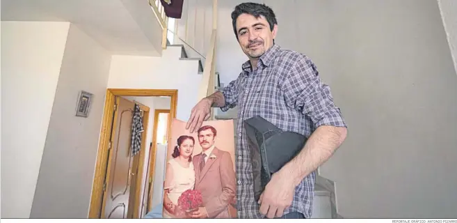  ?? REPORTAJE GRÁFICO: ANTONIO PIZARRO ?? Alejandro Ramos en las escaleras de su domicilio porta una imagen de sus padres recién casados y el tricornio que formaba parte del uniforme de su padre.
