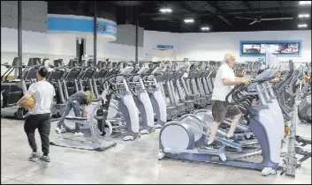  ??  ?? People work out Tuesday at Eos Fitness at 3325 E. Russell Road near Pecos Road. The fitness club took over some of the 50,000 square feet vacated by supermarke­t chain Vons during the recession.