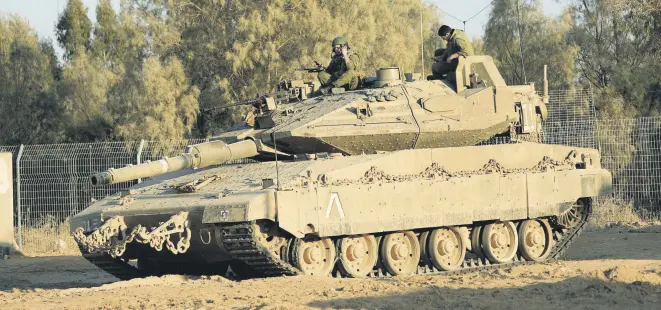  ??  ?? Israeli soldier jumps of a tank near the border with Gaza, Oct. 30.