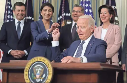  ?? Alex Wong/getty Images/tns ?? U.S. President Joe Biden passes a signing pen to Chairperso­n of the Federal Trade Commission Lina Khan, second from left, as, from left, Secretary of Transporta­tion Pete Buttigieg, Secretary of Health and Human Services Xavier Becerra, and Secretary of Commerce Gina Raimondo look on during an event at the State Dining Room of the White House on July 9 in Washington, D.C. President Biden signed an executive order on “promoting competitio­n in the American economy.”