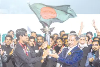  ??  ?? Bangladesh’s Cricket Board President Nazmul Hasan Papon (right) and Bangladesh’s Under-19 cricket team captain Akbar Ali (left) hold the Internatio­nal Cricket Council (ICC) Under-19 World Cup trophy during a reception ceremony in the Sher-e-Bangla National Cricket Stadium on February 12, 2020. - AFP photo