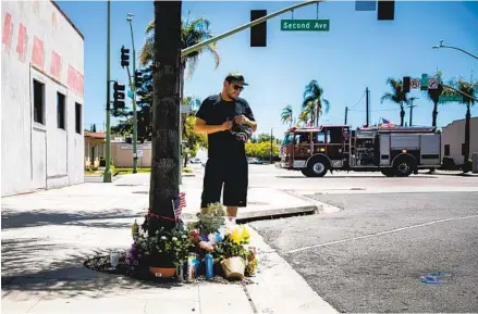  ?? SAM HODGSON U-T FILE ?? Escondido resident Jonathan Cruz pays his respects at a memorial to Steven John Olson at the corner of Second Avenue and Broadway on April 29 in Escondido. Olson was shot and killed by Escondido police Officer Chad Moore on April 21.