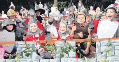  ??  ?? Ready for battle: These Cross Farm Infant School pupils were all smiles as they manned the parapets on their float.