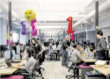  ?? Carlos Chavarría, © The New York Times Co. file ?? Employees in pre- pandemic times at the headquarte­rs of Slack in San Francisco in 2017. Most Slack employees have said they would like to have a mix of at- home and office work after the pandemic subsides.