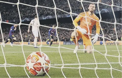  ??  ?? 0 Goalkeeper David de Gea looks back in despair after his blunder allowed Lionel Messi’s tame shot to squirm under his body.