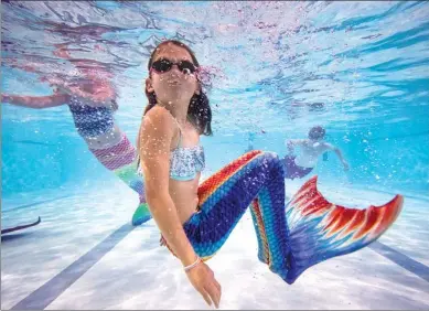  ?? JACK TAYLOR / GETTY IMAGES ?? Students participat­e in a Mayim Mermaid Academy lesson at the swimming pool at Bournemout­h Collegiate School in Bournemout­h, England.