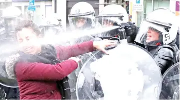  ??  ?? A woman is sprayed with teargas by the riot police officer during the ‘yellow vests’ protest against higher fuel prices, in Brussels. — Reuters photo