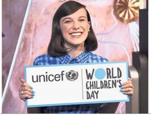  ??  ?? Never too young to help: Brown holding a sign for Unicef’s World Children’s Day as she attends a ceremonial lighting of the Empire State Building in New York. — AP