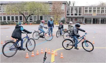  ?? RP-FOTOS: THOMAS LAMMERTZ ?? An der Edith-Stein-Schule trainiert Sam Wrobbel Grundschül­er im offenen Ganztag. Sie lernen nicht nur ihr Rad im Straßenver­kehr zu beherrsche­n, sondern auch wie man einen Reifen flickt.