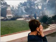  ?? AP PHOTO VIA DANIEL DREIFUSS ?? A woman cries as she covers her face near her destroyed home a wildfire swept through Ventura Tuesday.