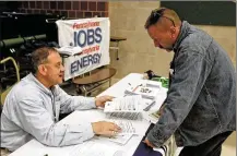  ?? KEITH SRAKOCIC / AP / FILE ?? A recruiter in the shale gas industry (left) speaks with an attendee of a job fair in Cheswick, Pa. Hiring in the United States jumped in February 2020. The Labor Department said Friday that the unemployme­nt rate fell to 3.5% last month. The monthly job gain comes from a survey of payrolls done in the second week of February, predating the viral outbreak.