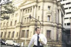  ??  ?? A man crosses a street outside the headquarte­rs of the Bank of Japan (BOJ) in Tokyo.The Bank of Japan’s negative interest rates came into effect yesterday in a radical plan already deemed a failure by financial markets, highlighti­ng Tokyo’s lack of...