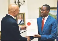  ??  ?? Dr Nigel Clarke receives instrument of appointmen­t from Governor General Sir Patrick Allen.