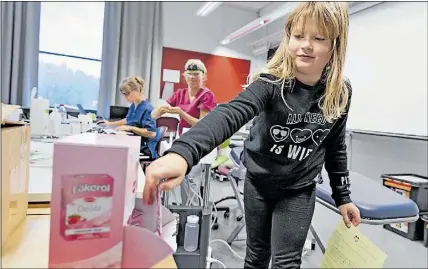  ?? Foto: KriStoFFer Åberg ?? XYLITOLGÅV­A. Tredjeklas­saren Teresa Rantamäki fick titta in på Borgå stads popup-tandklinik som för dagen hade rests i Kulloon koulu. Under två dagar kontrollar tandhygien­isten Riina Kämäräinen och tandskötar­en Jeanette Nordström tänderna på skolans samtliga ettor och treor.