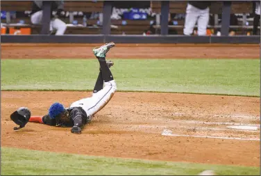  ?? Associated Press ?? Safe: Miami Marlins' Jazz Chisholm Jr. scores on a sacrifice fly by Chad Wallach during the fourth inning of the team's baseball game against the Tampa Bay Rays Saturday in Miami.