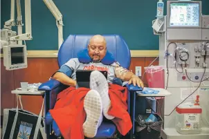  ??  ?? Leroy Gonzalez, football coach at Robertson in Las Vegas, N.M., attends one of his three weekly dialysis sessions Sept. 12.