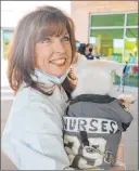  ?? Elizabeth Page Brumley Las Vegas Review-journal ?? Lola’s owner Lola Pokorny holds Bark-andre Furry with a special jersey at Summerlin Hospital for National Nurses Day on Wednesday.