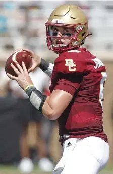  ?? PAUL CONNORS pHOTOS / bOSTON HeRALD ?? STRONG START: BC quarterbac­k Phil Jurkovec looks for an open receiver during the second quarter against Colgate at Alumni Stadium on Saturday. At left, Pat Garwo III leaps into the end zone for a rushing touchdown during the fourth quarter.