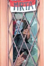  ?? FERNANDO LLANO THE ASSOCIATED PRESS FILE PHOTO ?? A Tupac Amaru guerrilla watches from the broken glass of the main door of Japan’s ambassador residence in Lima, where the guerrillas held 83 hostages in 1996. The rebel group appropriat­ed the name of Tupac Amaru, a muleteer and trader who claimed descent from Inca royals and was executed on May 18, 1781.